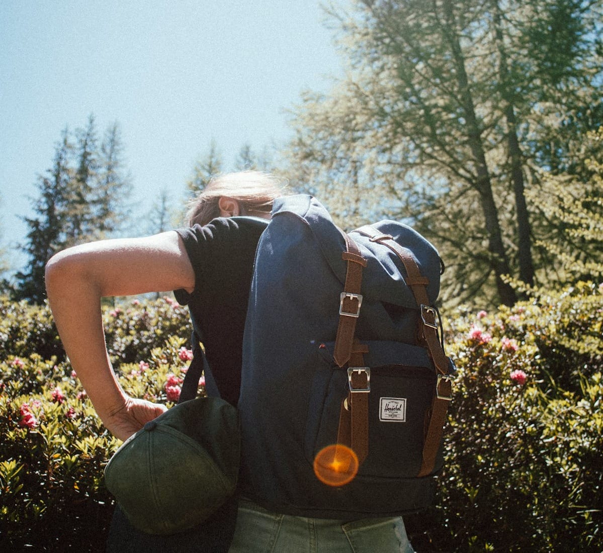 woman carrying bucket backpack facing backward